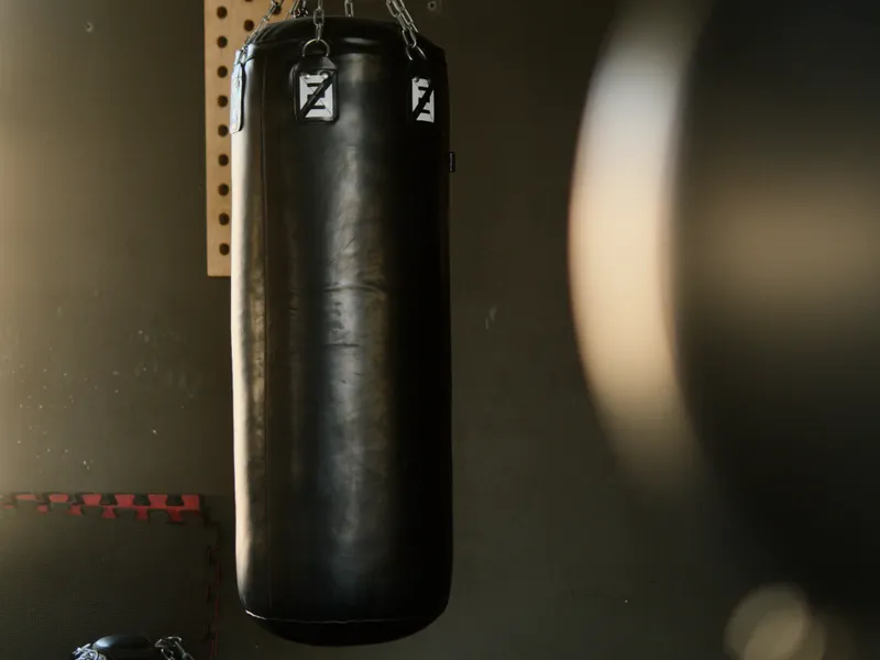 Bolsa de boxeo colgada en una sala con luz cálida