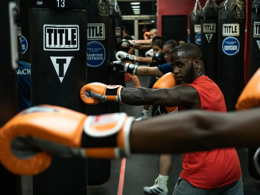 Clase de boxeo con guantes naranjas frente a las bolsas