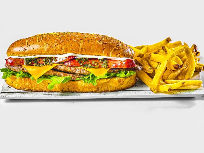 Chivito de pollo con lechuga y tomate acompañado de papas