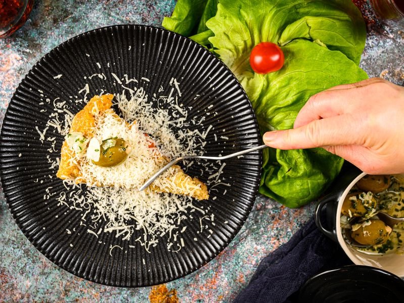 Fainá con muzzarella gratinada y aceitunas