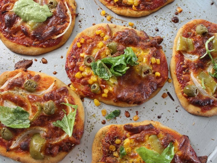 Bandeja con pizzetas recién horneadas y aceitunas