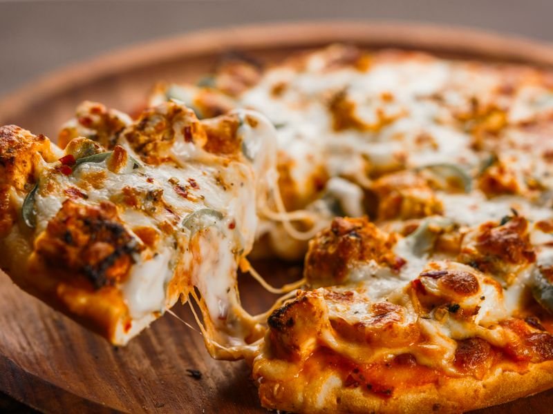 Media pizza de muzzarella servida en tabla
