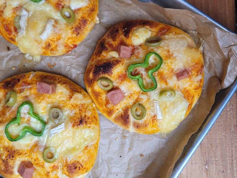 Pizzetas con jamón, queso y morrón sobre bandeja
